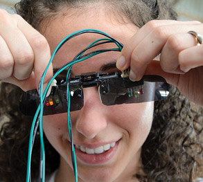 Female student working on optical engineering device
