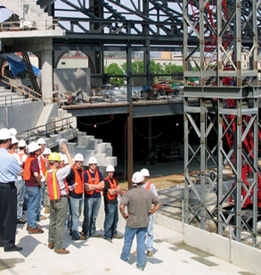 A large group of students tour the site of a major civil engineering project.